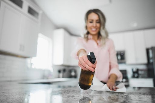 girl spraying on kitchen slab