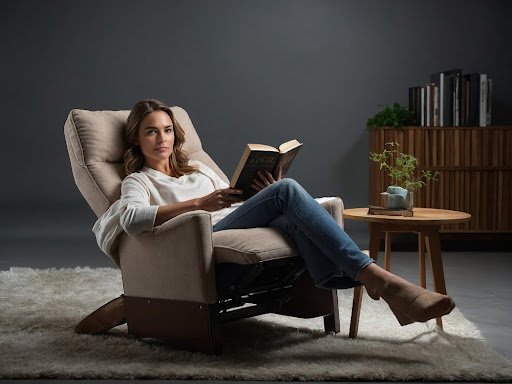 woman sitting comfortably on chair holding a book