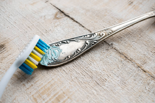 silver spoon cleaning with tooth paste and tooth brush