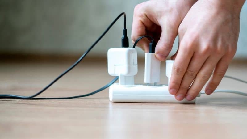 person unplugging charger from socket